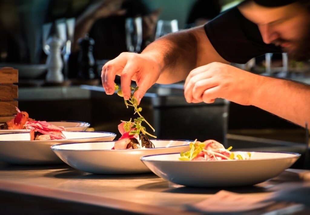 Chef finishing a plated dish for an institutional catering event